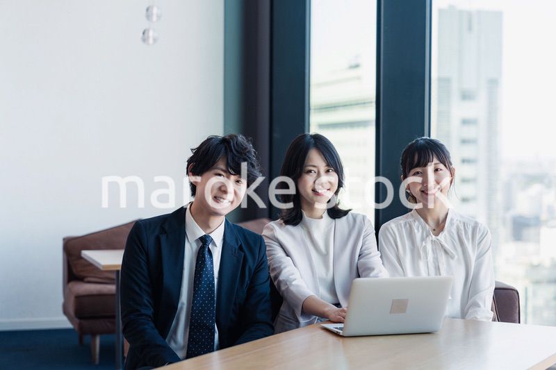 オフィスで仲良く話す若いビジネスパーソン