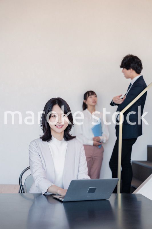 フリーアドレスのオフィスで働くビジネスウーマン