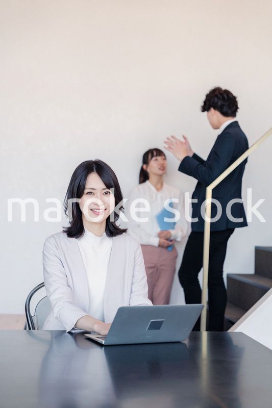 フリーアドレスのオフィスで働くビジネスウーマン