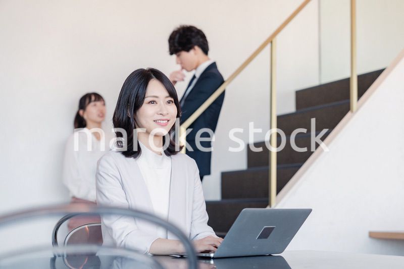 フリーアドレスのオフィスで働くビジネスウーマン