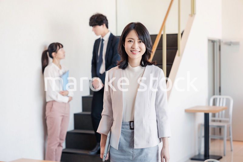 笑顔でオフィスを歩く女性経営者