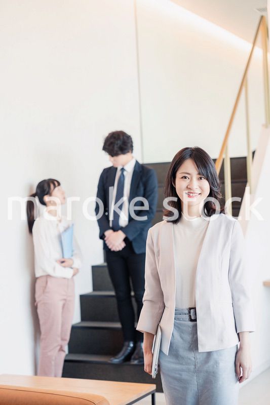 笑顔でオフィスを歩く女性経営者