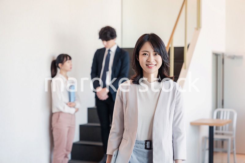 笑顔でオフィスを歩く女性経営者