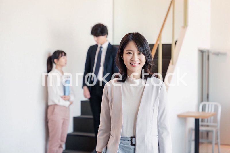 笑顔でオフィスを歩く女性経営者