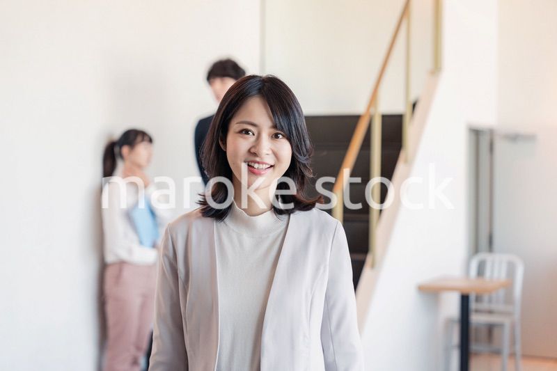 笑顔でオフィスを歩く女性経営者