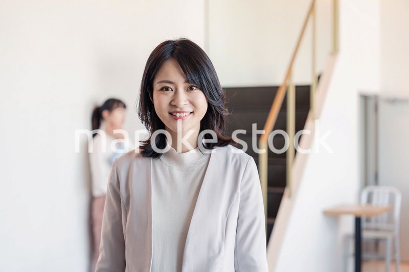 笑顔でオフィスを歩く女性経営者