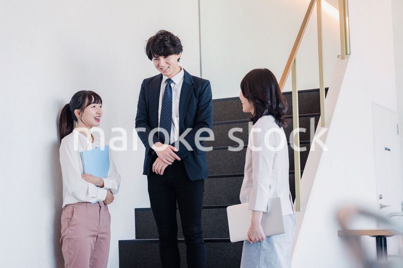 オフィスで仲良く話す若いビジネスパーソン