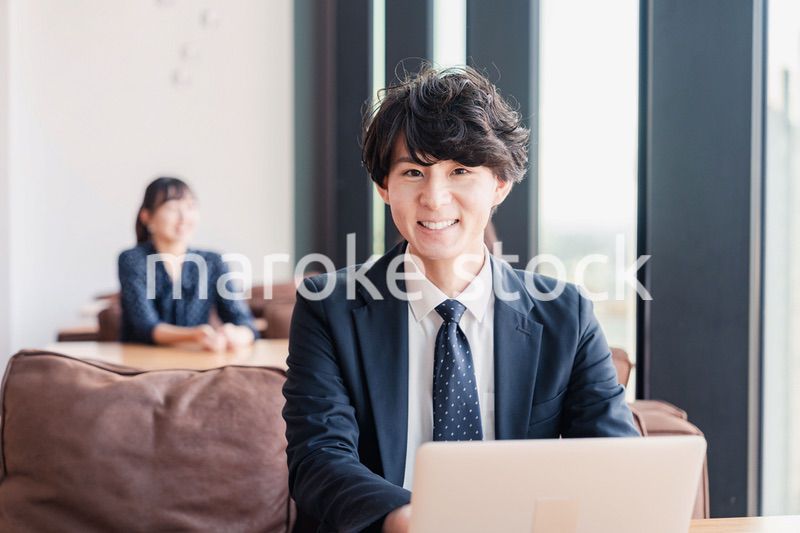 オフィスで笑顔で働くビジネスマン