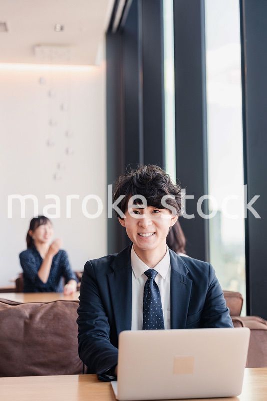 オフィスで笑顔で働くビジネスマン