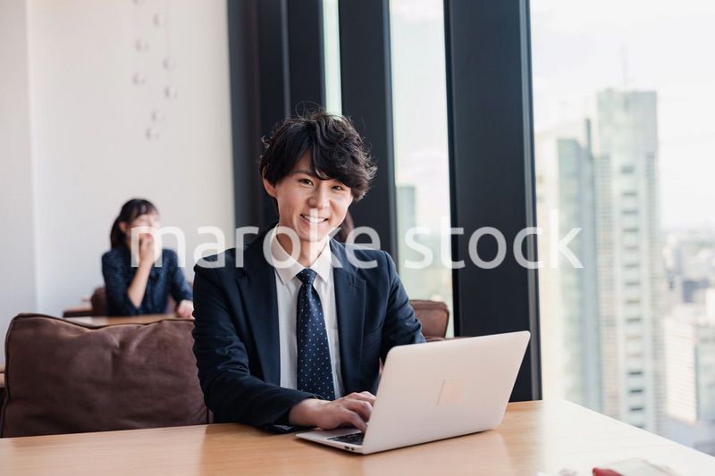 オフィスで笑顔で働くビジネスマン