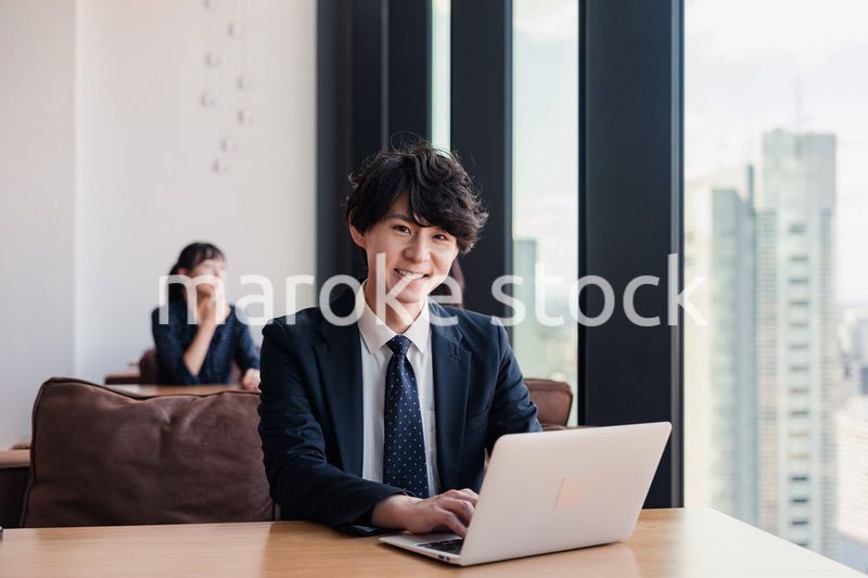 オフィスで笑顔で働くビジネスマン