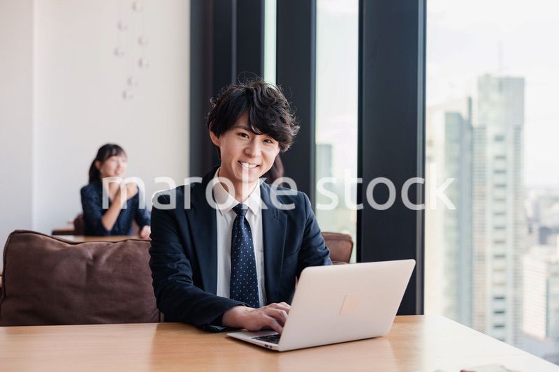 オフィスで笑顔で働くビジネスマン