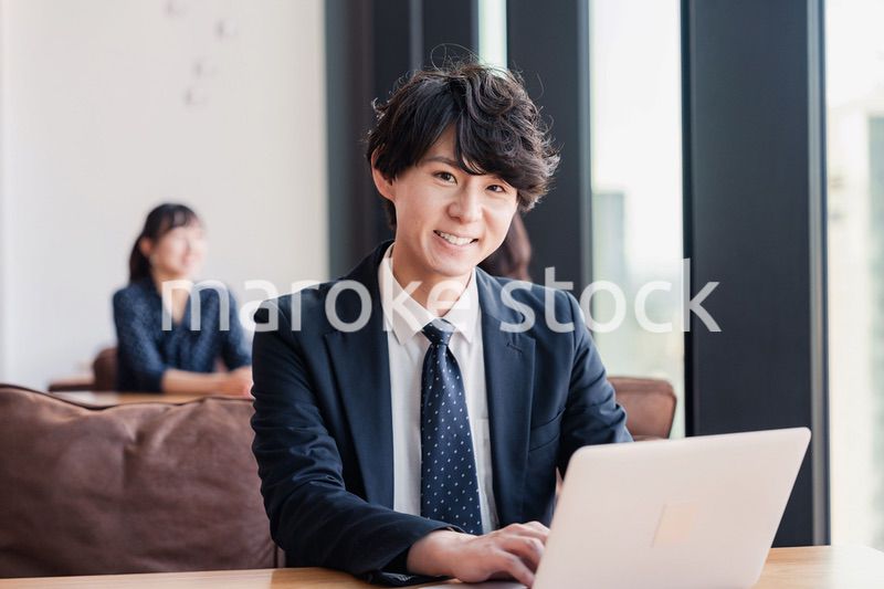 オフィスで笑顔で働くビジネスマン