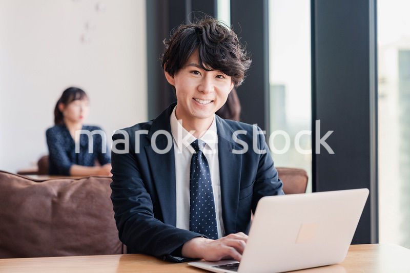 オフィスで笑顔で働くビジネスマン