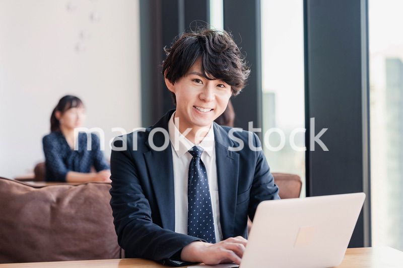 オフィスで笑顔で働くビジネスマン