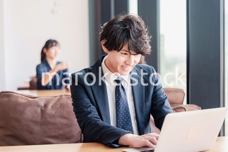 オフィスで笑顔で働くビジネスマン