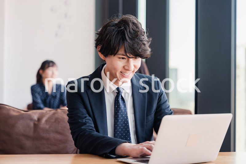 オフィスで笑顔で働くビジネスマン