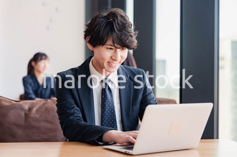 オフィスで笑顔で働くビジネスマン