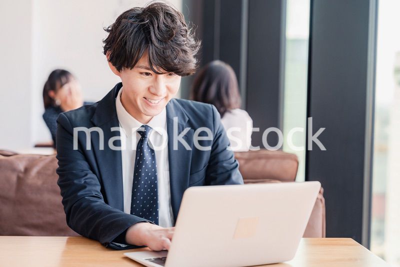 オフィスで笑顔で働くビジネスマン