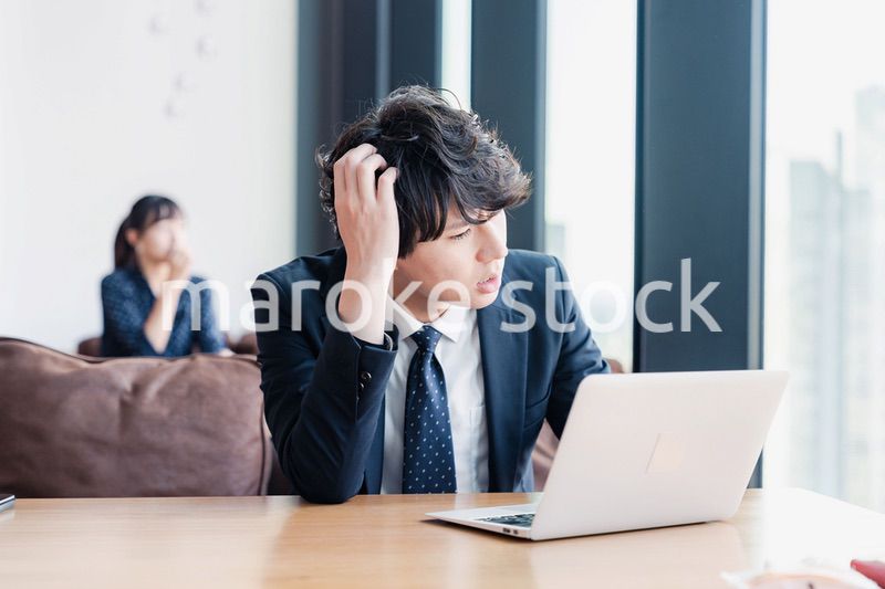 オフィスで頭を抱えるビジネスマン