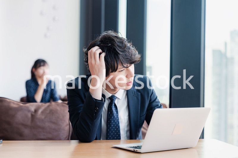 オフィスで頭を抱えるビジネスマン