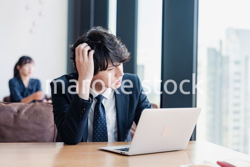 オフィスで頭を抱えるビジネスマン