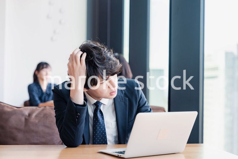 オフィスで頭を抱えるビジネスマン