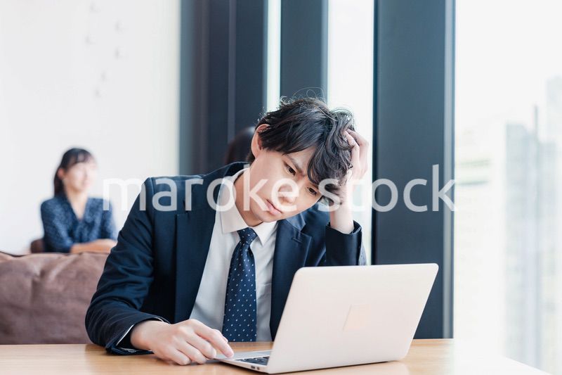 オフィスで頭を抱えるビジネスマン