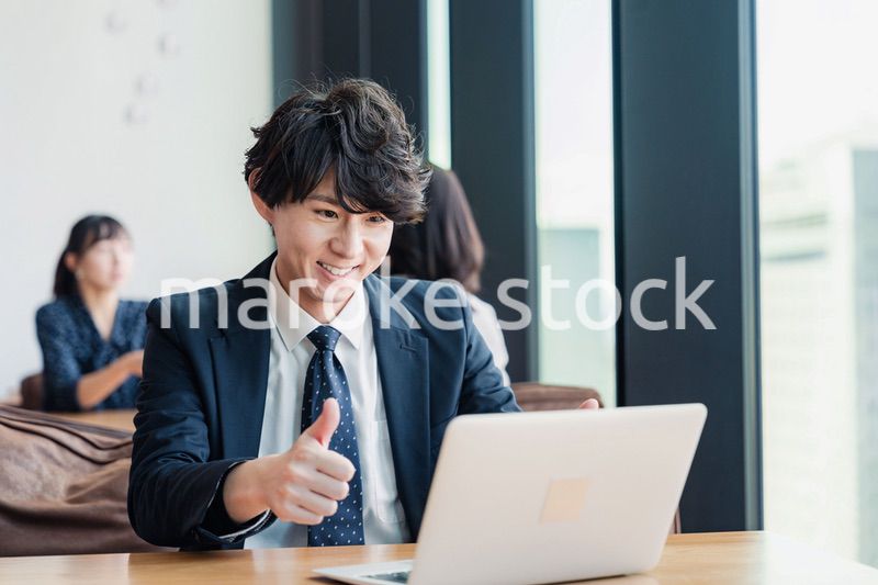 オンラインミーティングで喜ぶビジネスマン