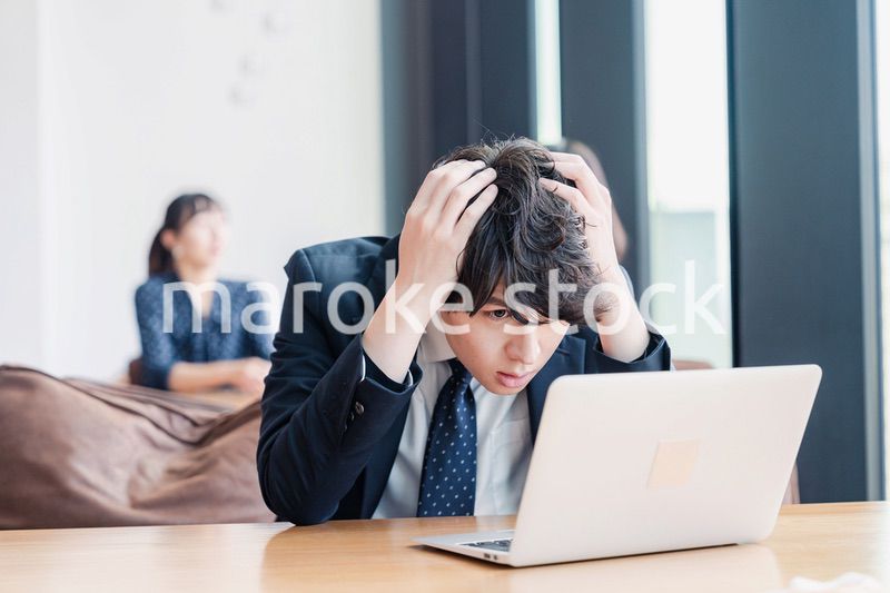 オフィスで頭を抱えるビジネスマン
