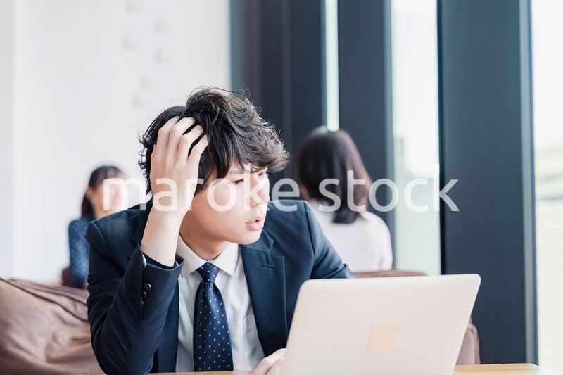 オフィスで頭を抱えるビジネスマン