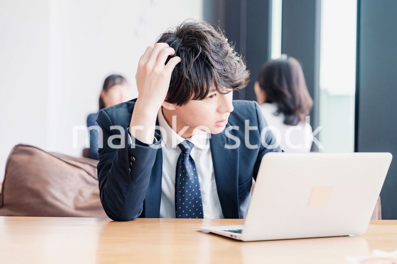 オフィスで頭を抱えるビジネスマン