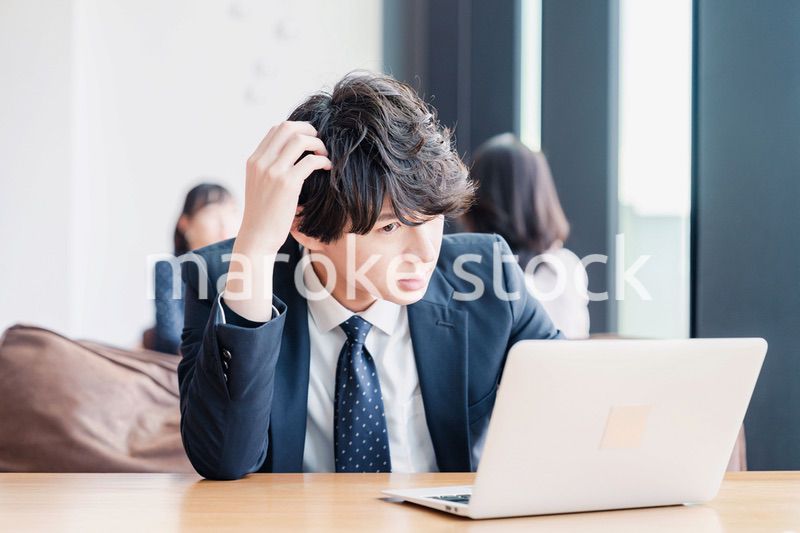オフィスで頭を抱えるビジネスマン