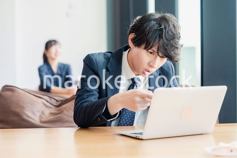 オフィスでパソコンと格闘するビジネスマン