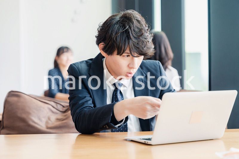 オフィスでパソコンと格闘するビジネスマン