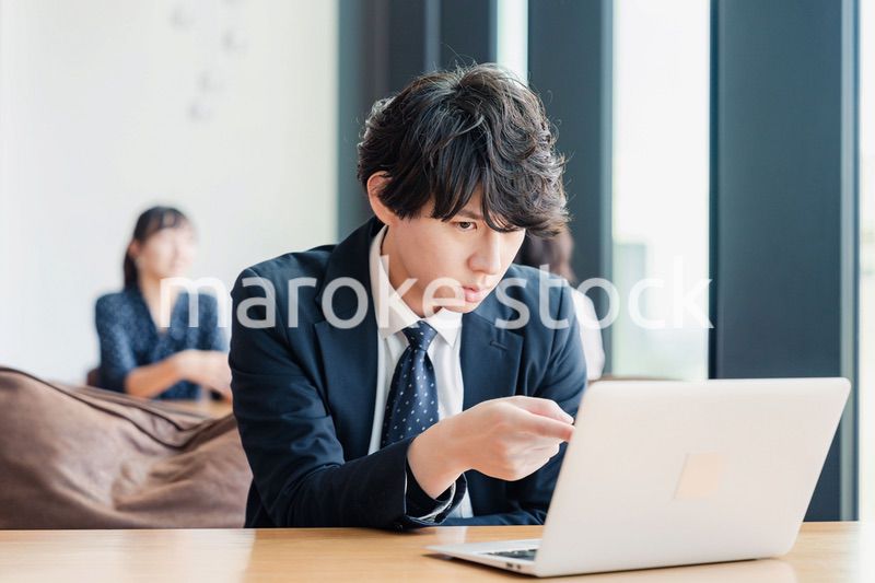 オフィスでパソコンと格闘するビジネスマン