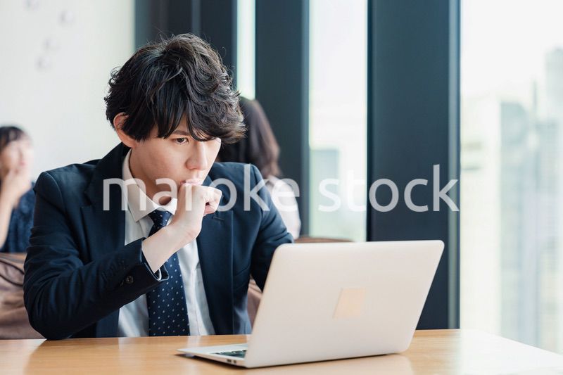 オフィスでパソコンと格闘するビジネスマン