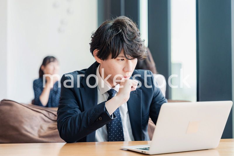 オフィスでパソコンと格闘するビジネスマン