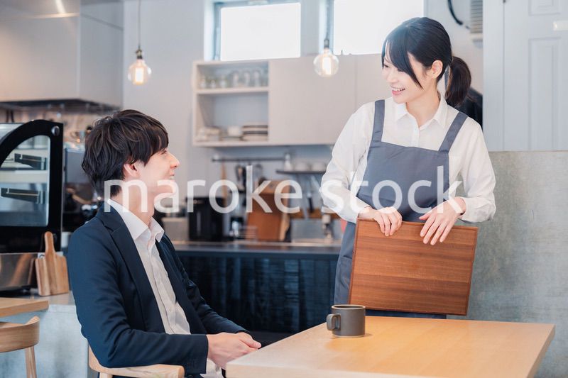 カフェで男性客と話すスタッフ