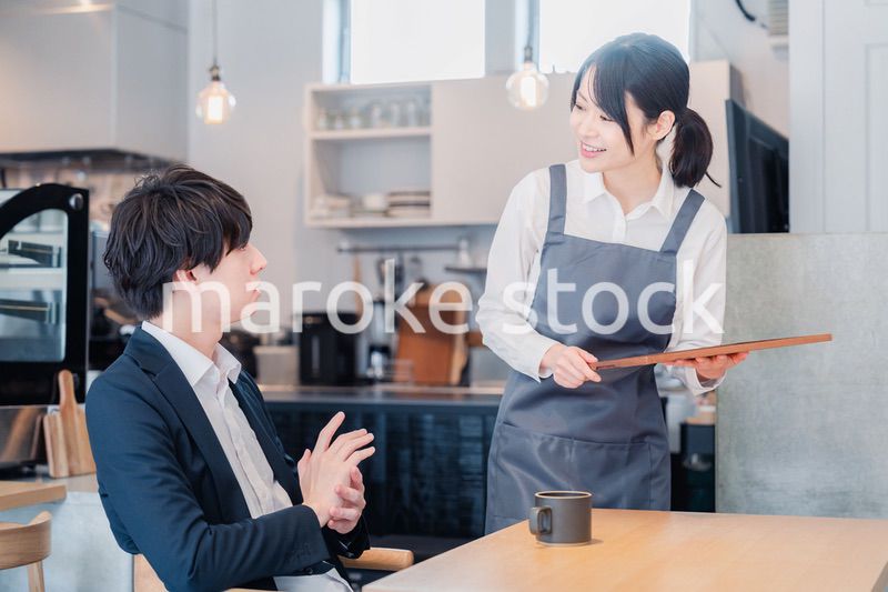 カフェで男性客と話すスタッフ