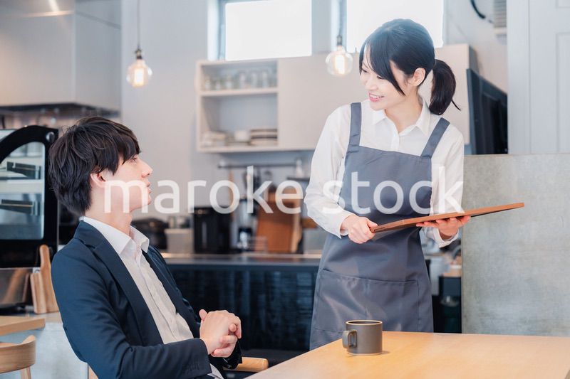 カフェで男性客と話すスタッフ
