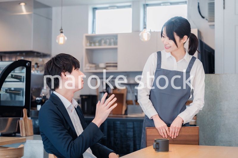 カフェで男性客と話すスタッフ