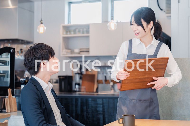 カフェで男性客と話すスタッフ