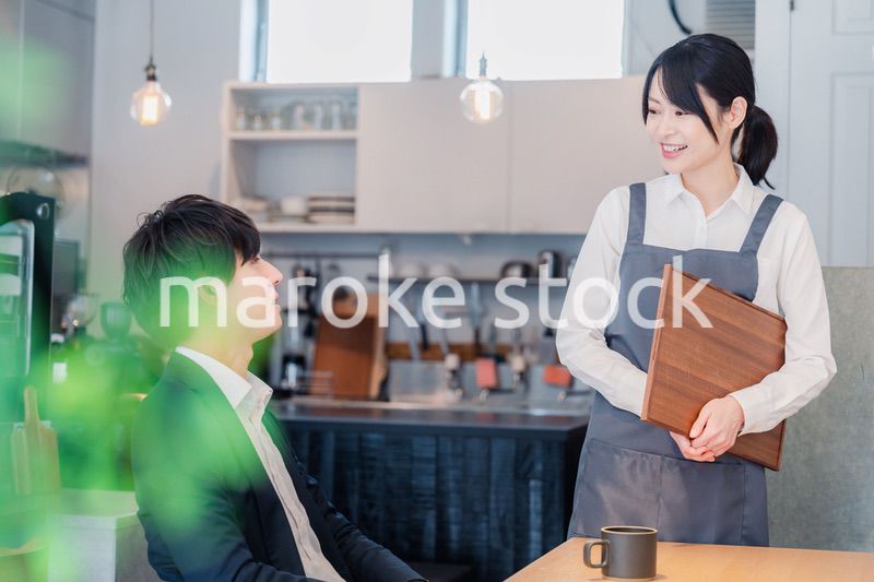 カフェで男性客と話すスタッフ