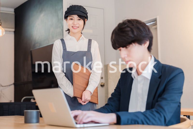 カフェで男性客と話すスタッフ