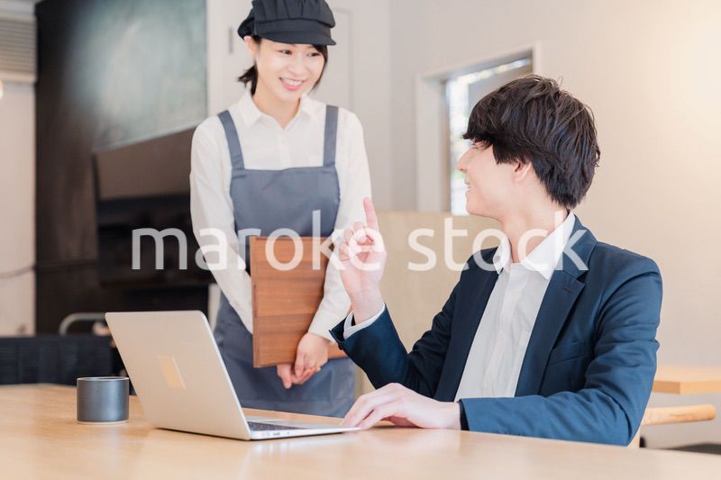 カフェで男性客と話すスタッフ
