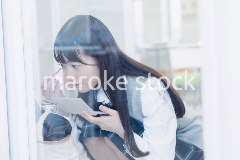 学校でメイクをする女子高生
