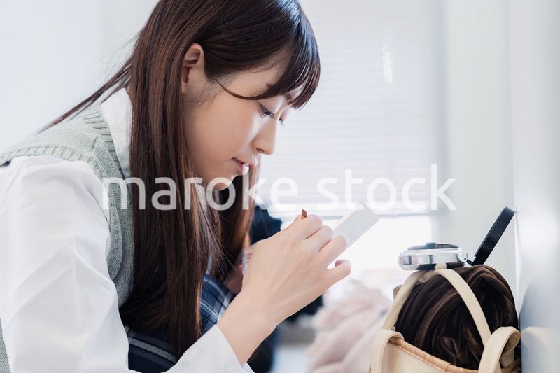 学校でメイクをする女子高生