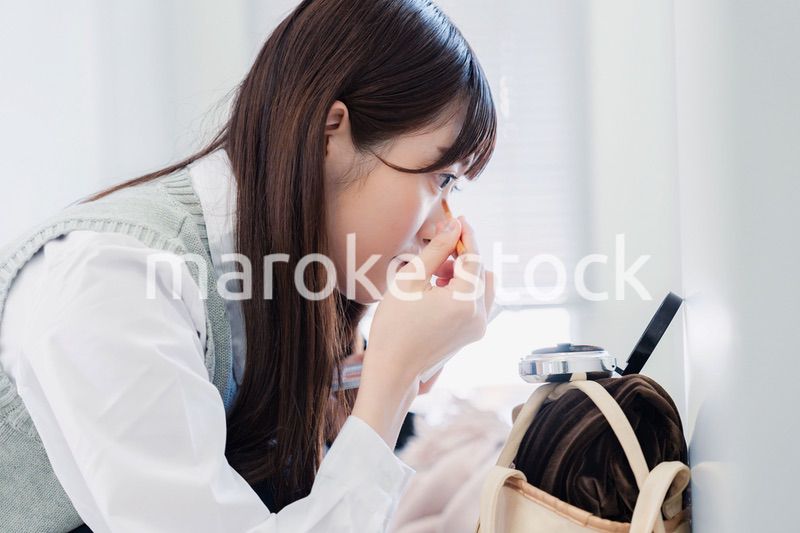学校でメイクをする女子高生