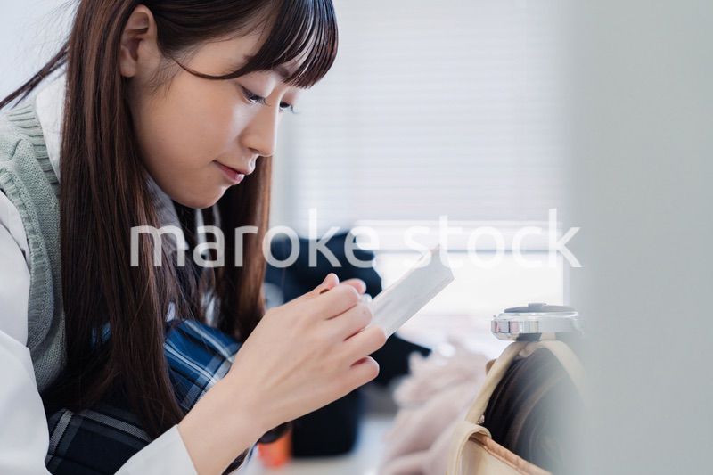 学校でメイクをする女子高生